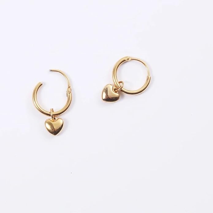 Pair of gold heart-shaped hoop earrings resting on a plate.