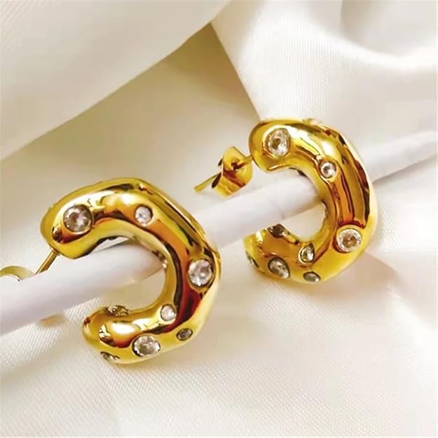 Gold tone earrings with sparkling crystal stones, perfect for adding a touch of elegance to any outfit.