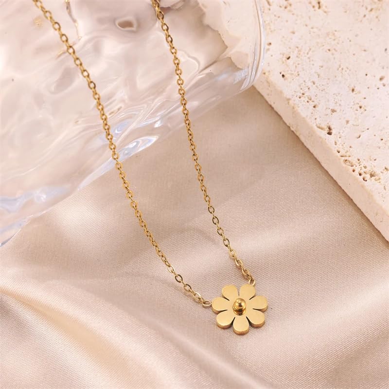 A dainty flower charm on a gold necklace.