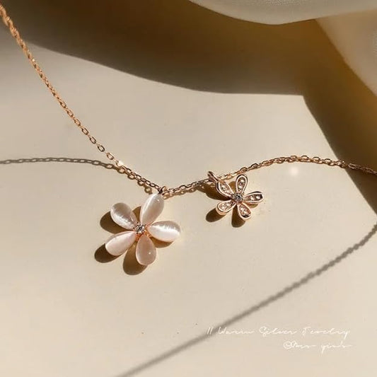 Rose gold necklace with flower and butterfly design, elegant and delicate jewelry piece.