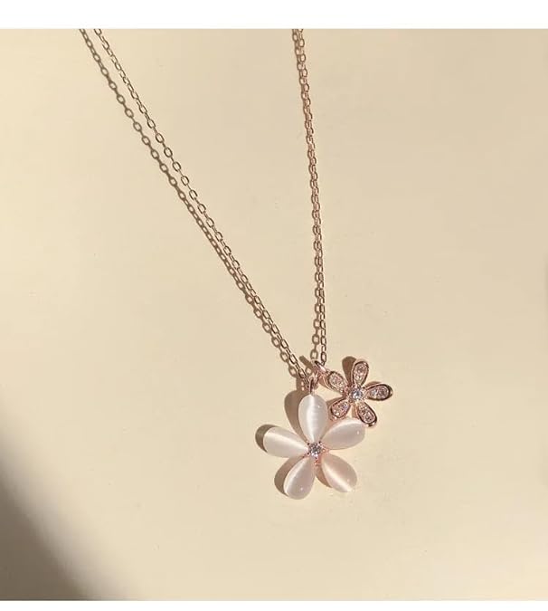 A white flower necklace with a pink flower on it.