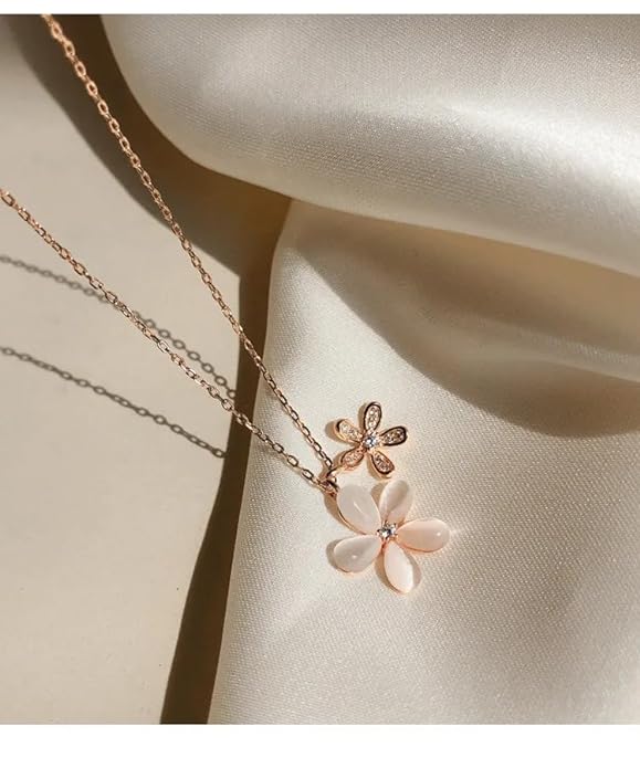 A necklace with a white and pink flower design.