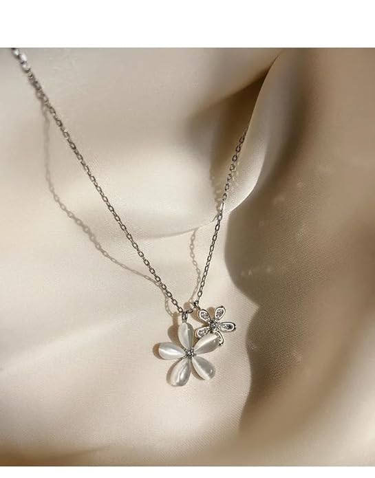 Silver necklace with delicate flower pendant.