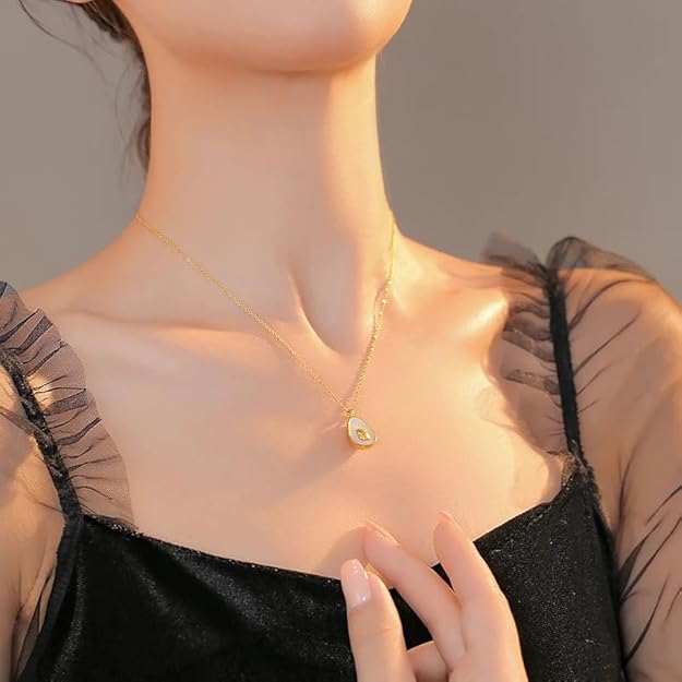 A woman showcasing a gold necklace adorned with a heart, representing beauty and personal expression in her fashion.