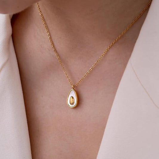 A woman elegantly wears a gold tear pendant necklace, showcasing its delicate design against her skin.