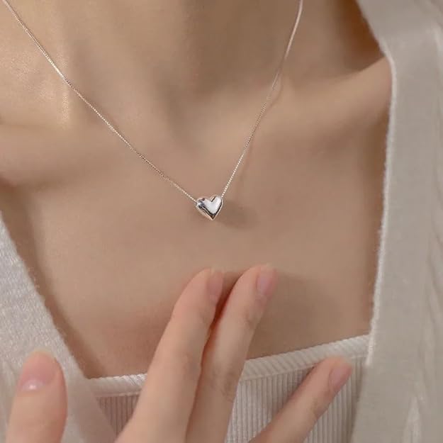 A heart-shaped pendant elegantly displayed on a delicate silver chain, showcasing a timeless piece of jewelry.