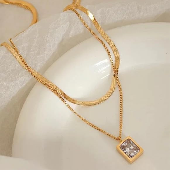  Luxurious gold necklace with square pendant, nestled in a gift box.