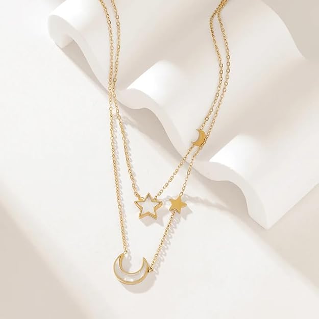 Enhance your outfit with this chic gold necklace, showcasing layers of chains with charming stars and moon details.