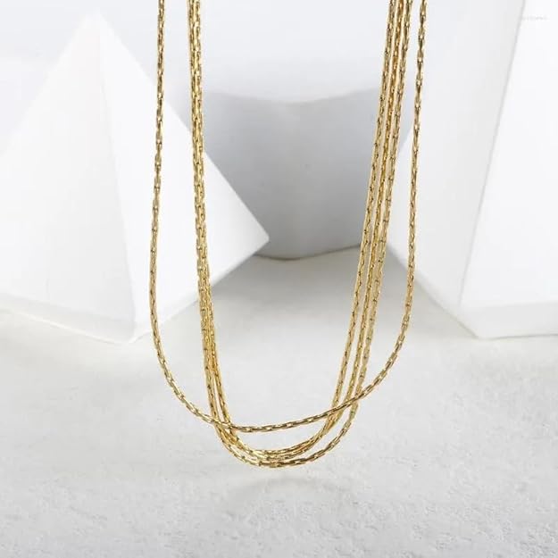 Beautiful gold chain necklace resting inside a luxurious brown box.