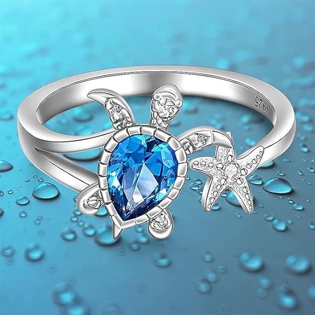 Turtle ring with blue topaz and starfish, perfect for ocean lovers.