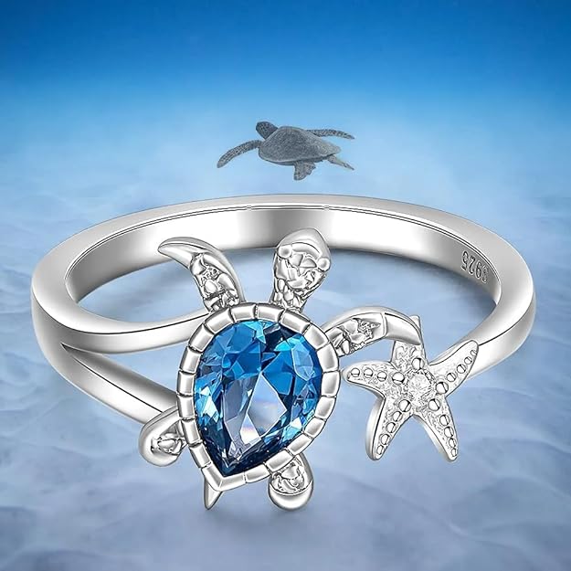 Stylish ring showcasing a turtle, blue topaz, and starfish elements.