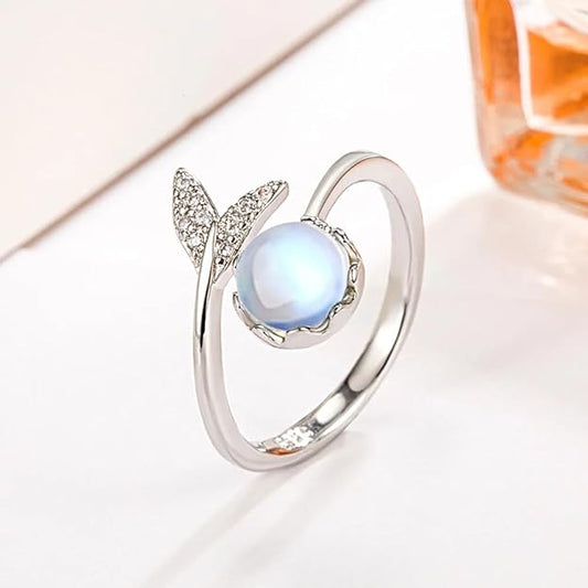 A stunning ring featuring a blue moonstone and a sparkling diamond.