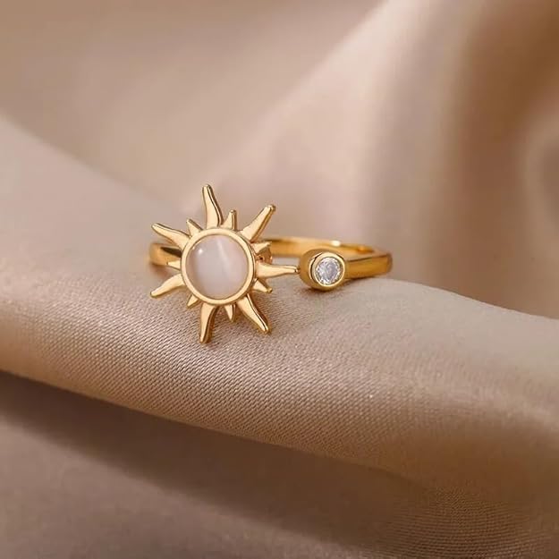 A sun-shaped gold ring with a white stone.