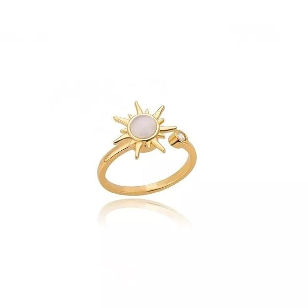 A gold ring featuring a white stone, reminiscent of a sun.