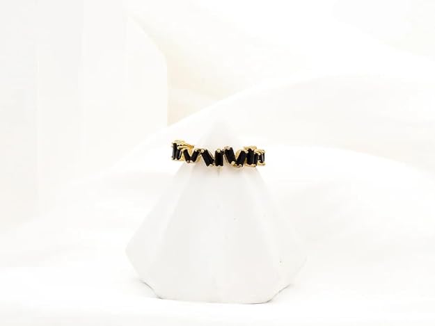 Elegant gold ring with black diamond detail.