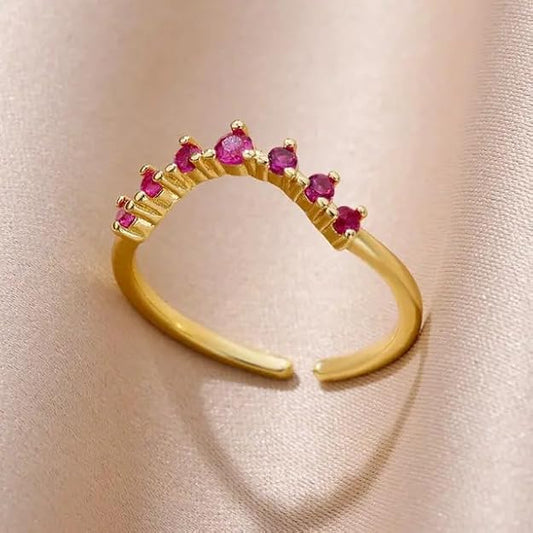 A shiny gold ring with sparkling pink stones, perfect for adding a touch of elegance to any outfit.