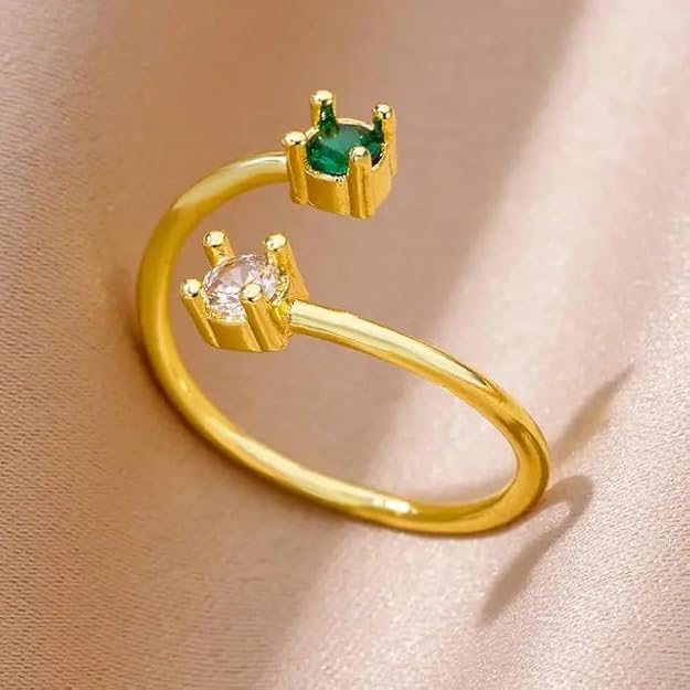 Gold ring with two green stones, elegant jewelry piece.