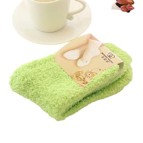 A green towel neatly folded beside a steaming cup of coffee on a wooden surface.
