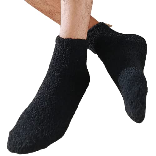 A man stands wearing black socks paired with stylish black shoes, showcasing a sleek and coordinated look.

