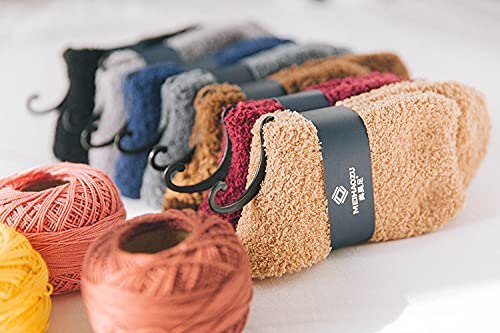 A vibrant pair of socks alongside a ball of yarn, all displayed on a bright white background, inviting creativity.

