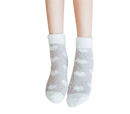 A close-up of a woman's feet in cozy socks decorated with cute heart patterns.