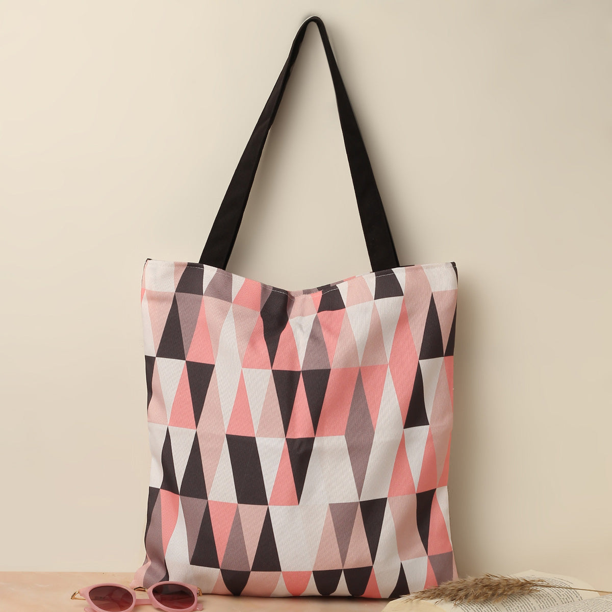 Fashionable pink and black tote bag adorned with triangles.