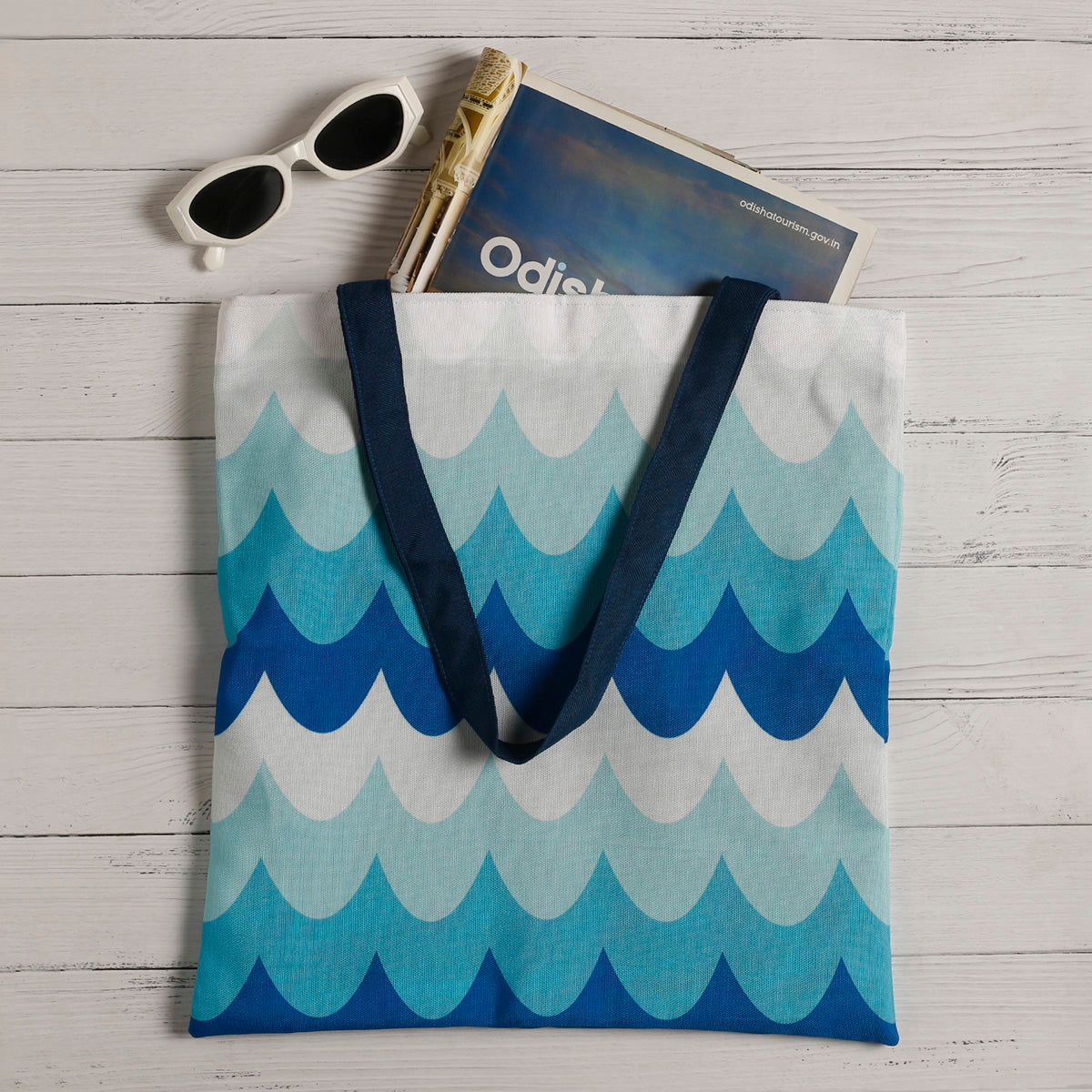  Stylish blue and white tote with sunglasses and sunscreen.