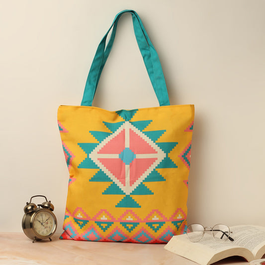 A yellow and blue tote bag with a pink and turquoise design.