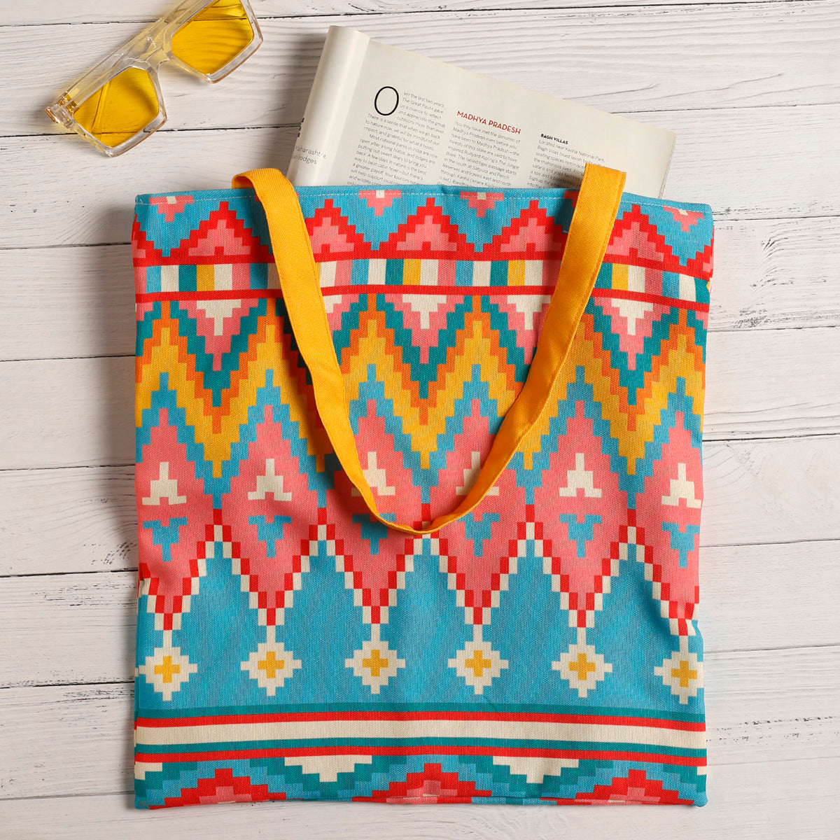 Bright and colorful tote bag with a yellow handle.