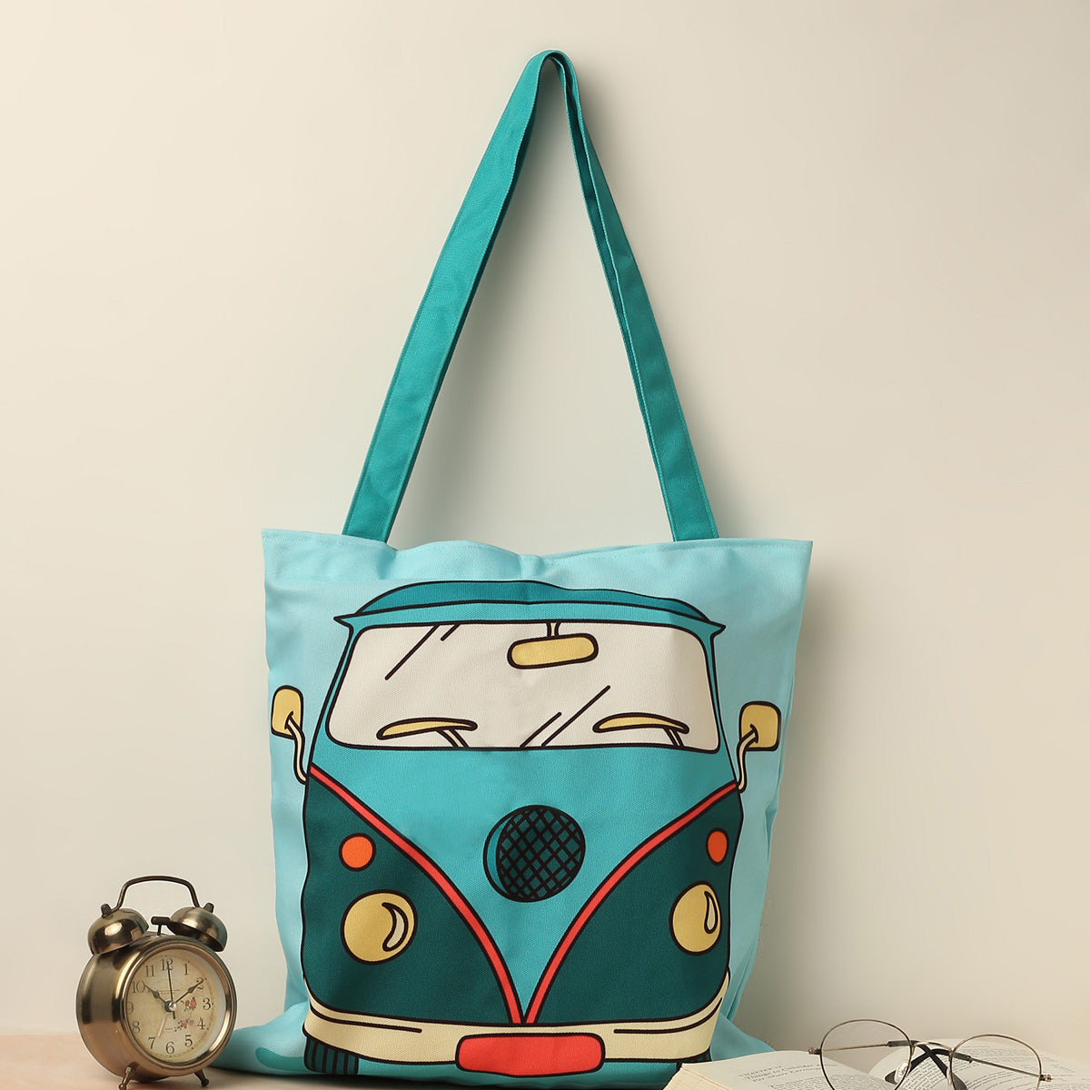  A stylish tote bag featuring a blue and green Volkswagen bus design, perfect for casual outings and everyday use.