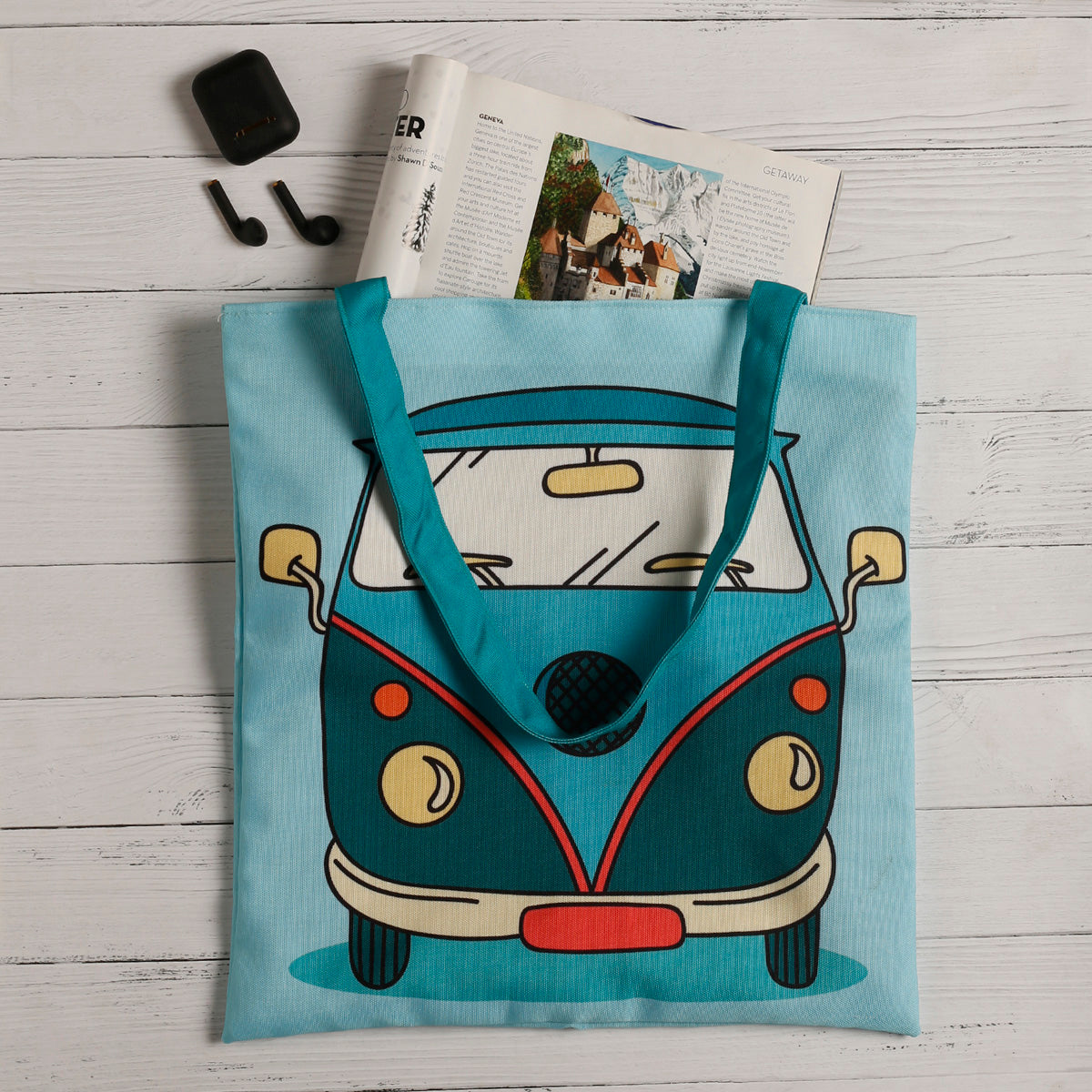  A vibrant tote bag showcasing a blue and green VW bus, ideal for carrying essentials with a touch of retro charm.