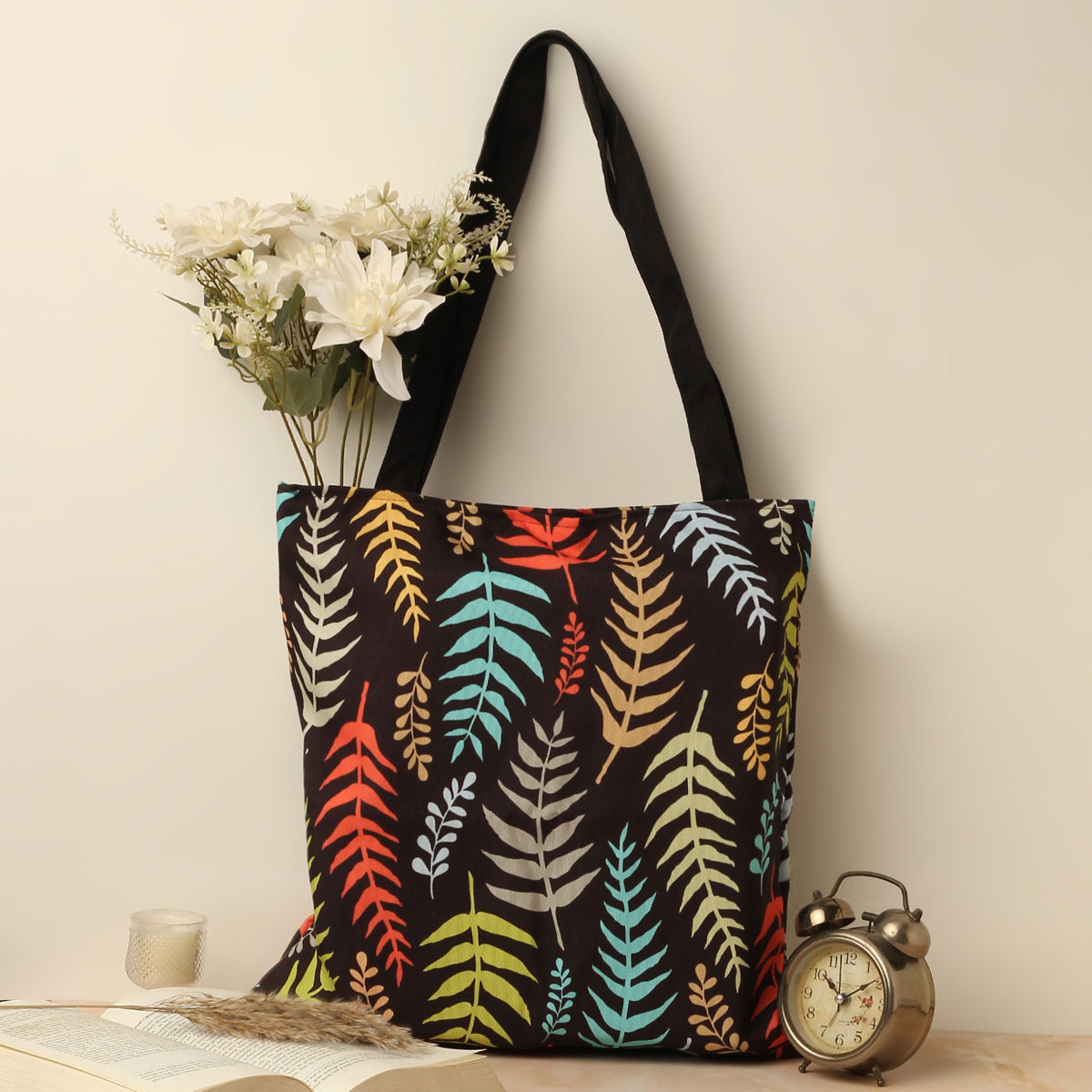 A tote bag with colorful leaves on it.