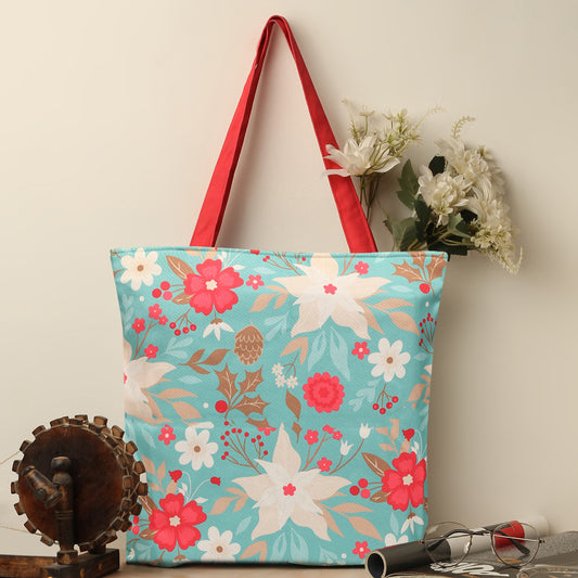  A tote bag with red handles featuring a floral pattern design.