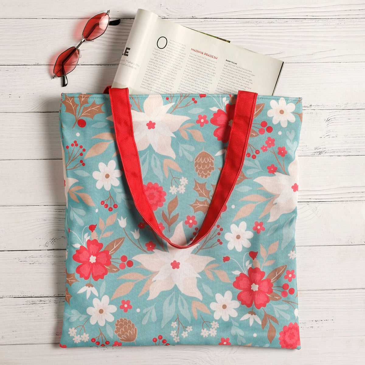 Floral pattern tote bag with vibrant red handles.