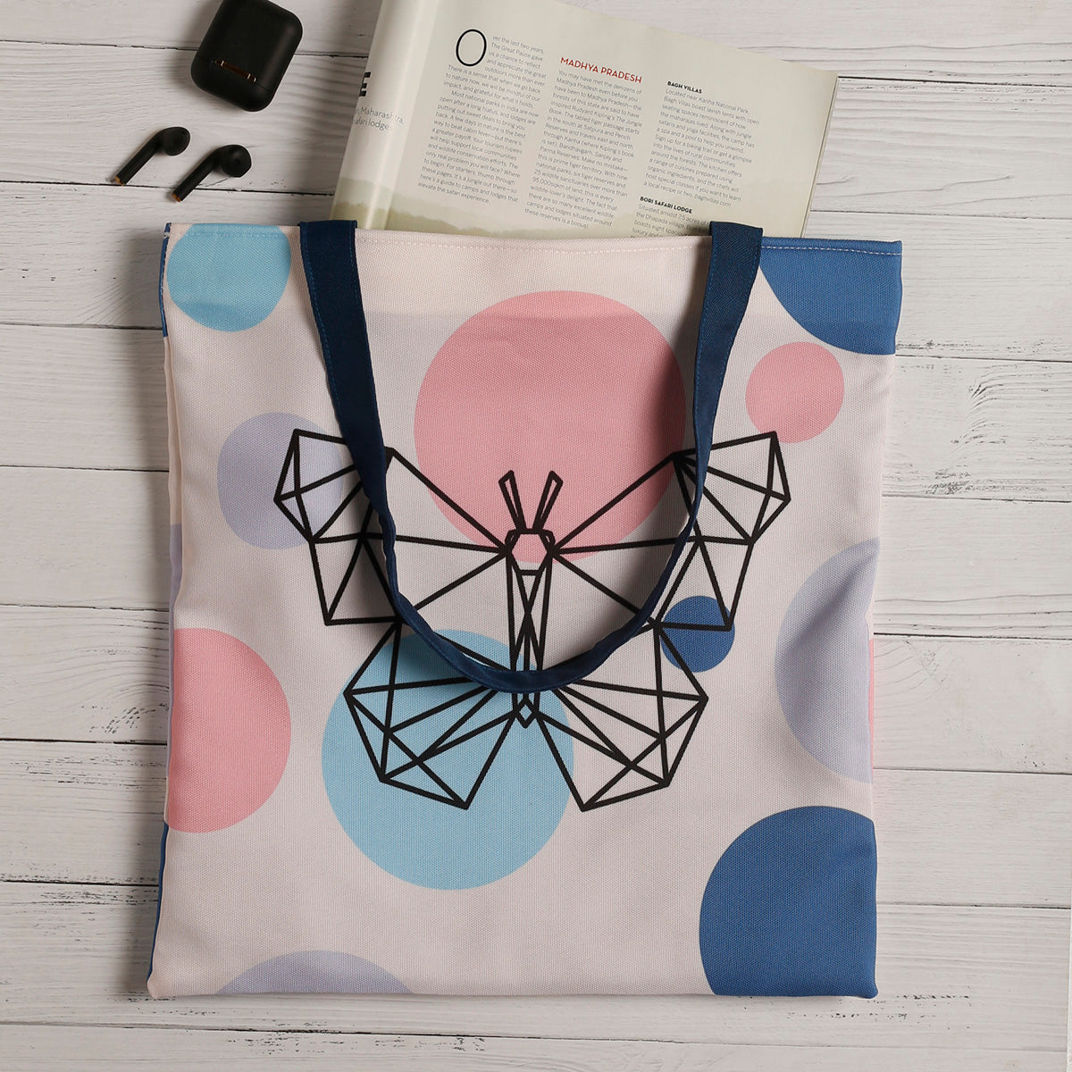  A charming butterfly tote bag adorned with a vibrant pink, blue, and white polka dot pattern, ideal for carrying essentials