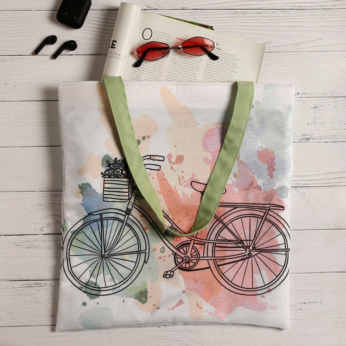 Lifestyle shoot of Tote Bag with pastel color print of cute vintage cycle with a green handle complimenting the overall design of the tote bag.